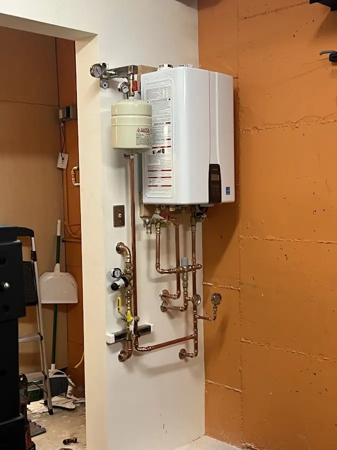 Plumbing technician inspecting water heater connections in Firestone